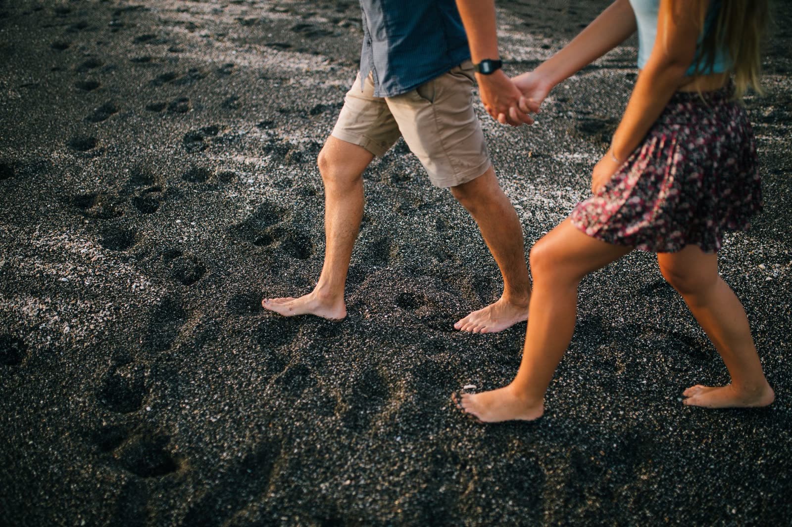 Pareja descalza caminando sobre la arena de la playa