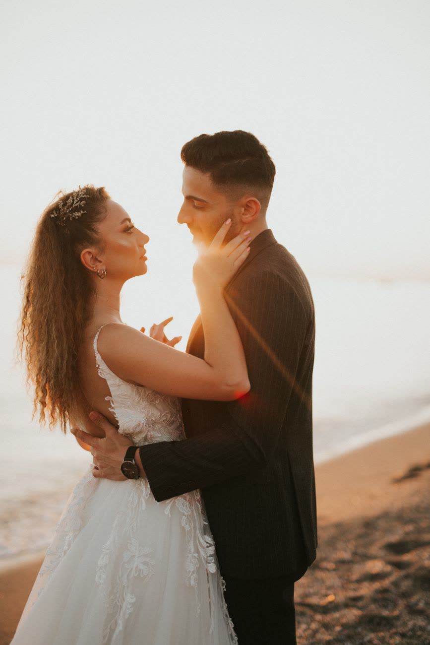Novios abrazados en la playa al atardecer, Riviera Maya