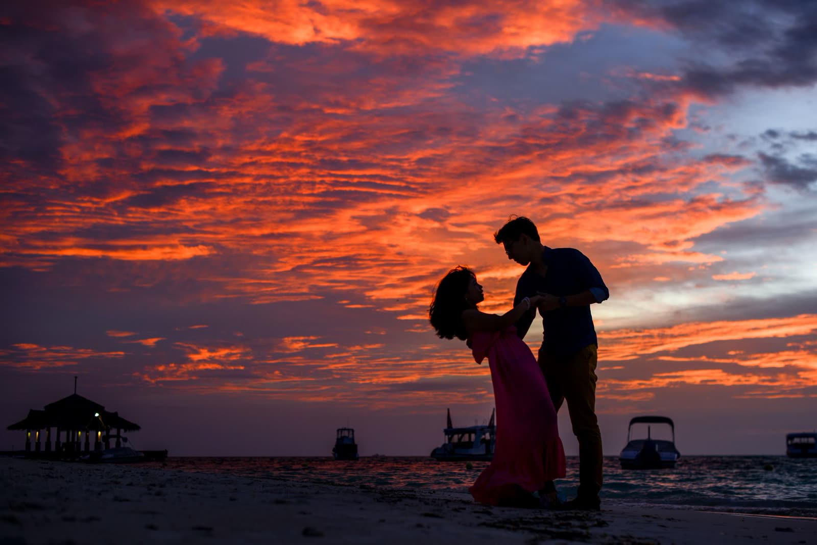 Silueta de una pareja frente al mar al atardecer